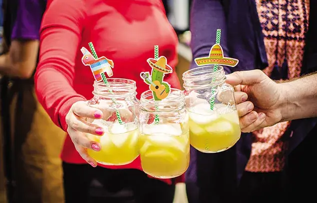 Brindis con cócteles amarillos en frascos decorados con temática mexicana, barras para eventos sociales premium.
